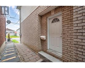 A white door is on a brick wall.