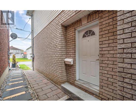 A white door is on a brick wall.