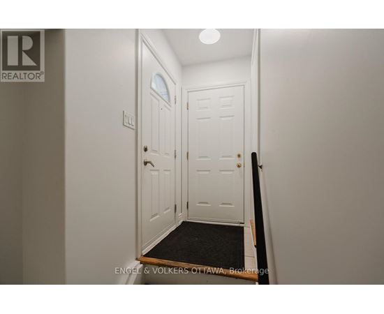 A white door with a black mat in front of it.