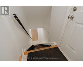 A hallway with a staircase leading to the second floor.