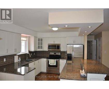 A kitchen with white cabinets and a black countertop.
