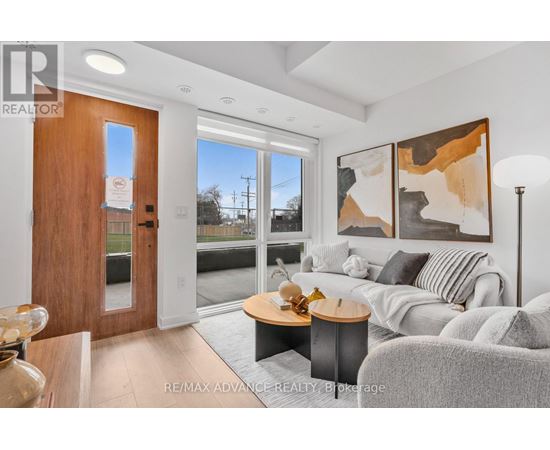 A modern living room with a grey couch and a wooden door.