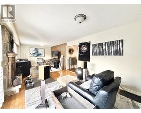 A living room with a black leather couch and a fireplace.