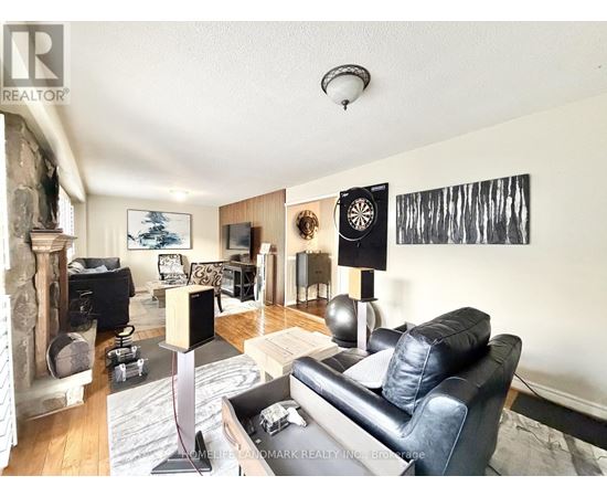 A living room with a black leather couch and a fireplace.