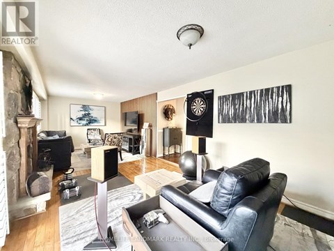 A living room with a black leather couch and a fireplace.