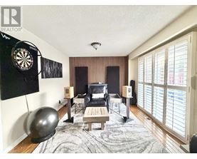 A room with a dartboard on the wall and a couch.