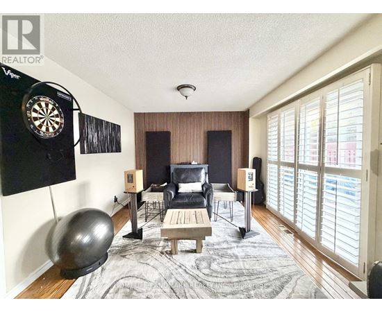 A room with a dartboard on the wall and a couch.