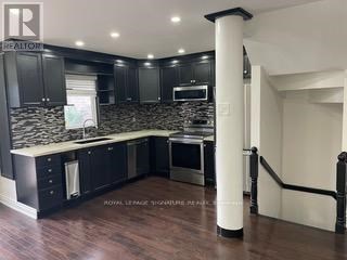 A modern kitchen with dark wood cabinets and a white island.