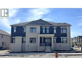 A modern two-story house with a black and white exterior is under construction.