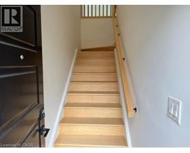 A staircase with wooden steps and a black railing.