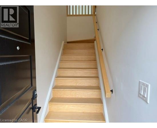 A staircase with wooden steps and a black railing.