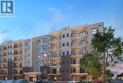 A modern apartment building with multiple balconies and a clear sky in the background.