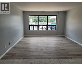 A room with a large window and wooden flooring.