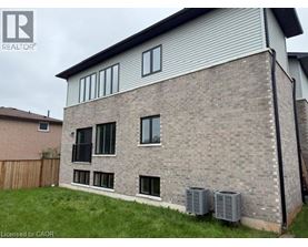 A house with a grey brick exterior and a white window.
