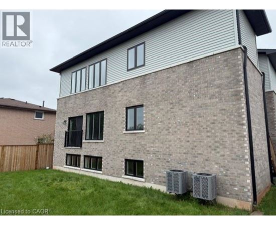 A house with a grey brick exterior and a white window.