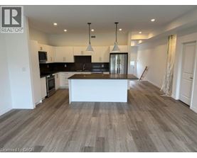 A spacious kitchen with a central island and pendant lights.