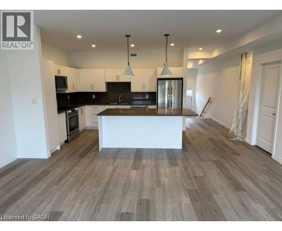 A spacious kitchen with a central island and pendant lights.