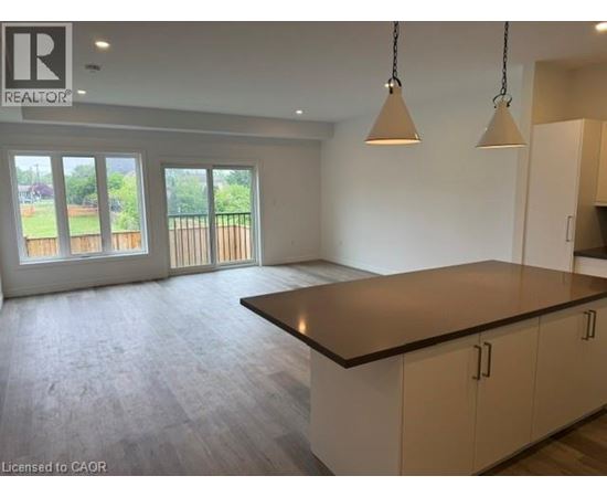 A spacious kitchen with a large island and pendant lights.