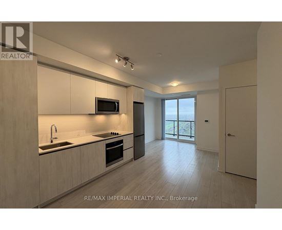 A modern kitchen with a sink, stove, and microwave.