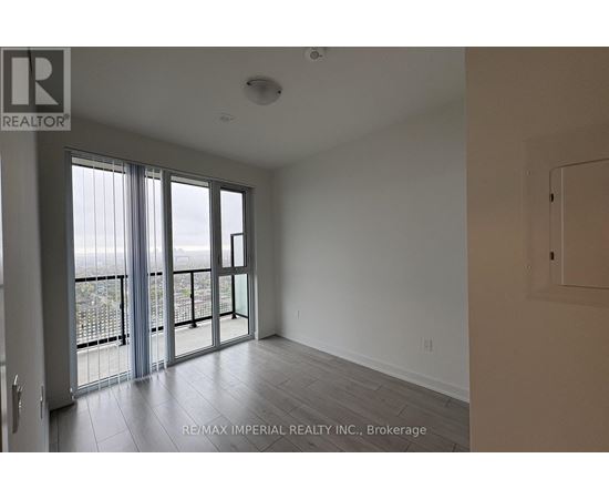 A room with a sliding glass door leading to a balcony.