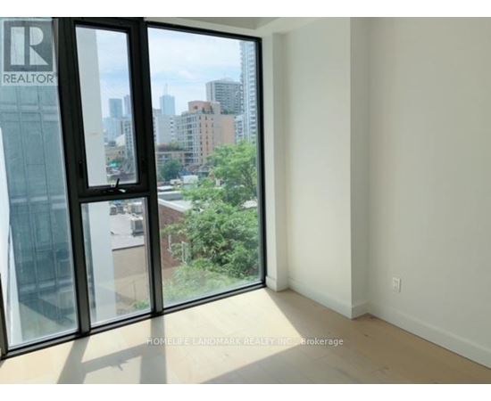 A room with a view of the city through large windows.