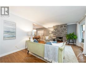 A living room with a stone fireplace and a painting on the wall.