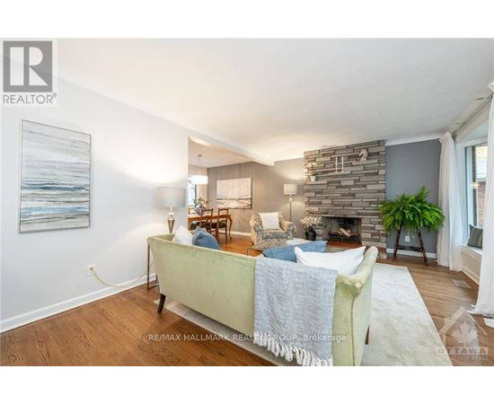A living room with a stone fireplace and a painting on the wall.