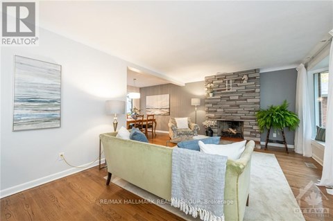 A living room with a stone fireplace and a painting on the wall.