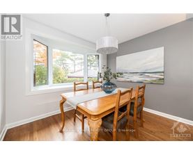 A dining room with a wooden table and chairs.