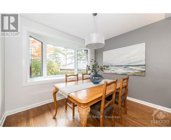 A dining room with a wooden table and chairs.