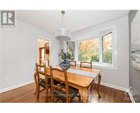 A dining room with a wooden table and chairs.