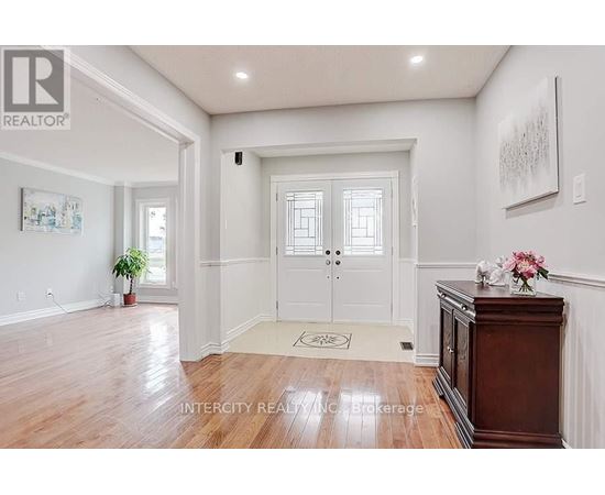 A hallway with a wooden floor and white walls.