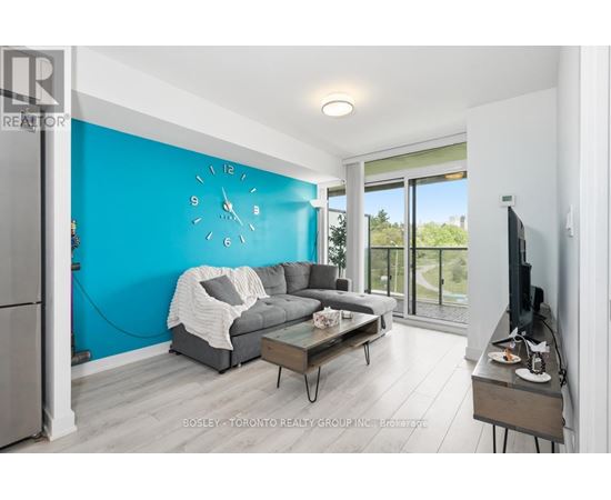 A living room with a grey couch and a blue wall.