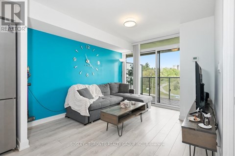 A living room with a grey couch and a blue wall.