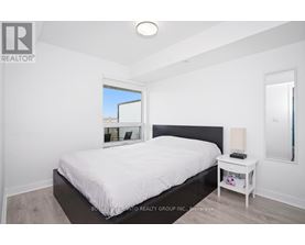 A bedroom with a large bed and a small nightstand.