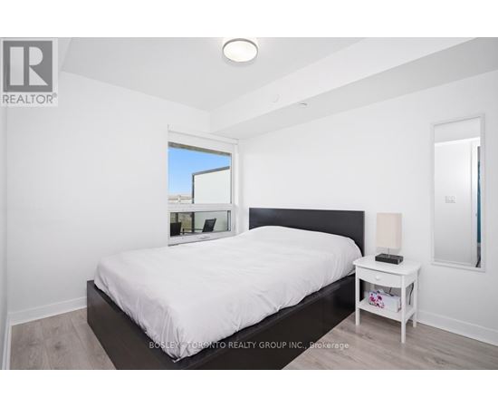 A bedroom with a large bed and a small nightstand.