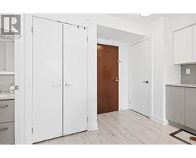 A kitchen with white cabinets and a wooden door.