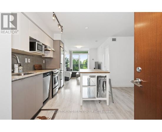 A modern kitchen with a dining area in the background.