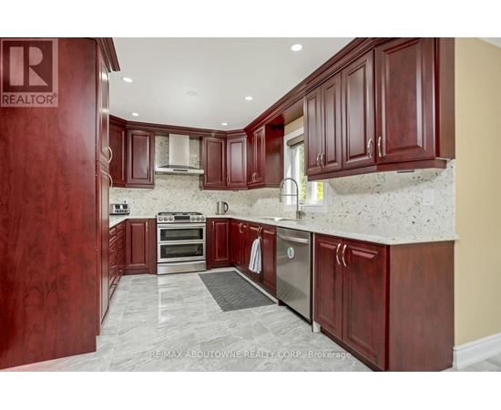 A kitchen with wooden cabinets and a stainless steel dishwasher.