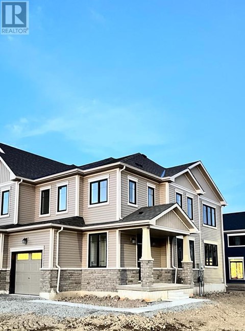 A large, two-story house with a garage is under construction.