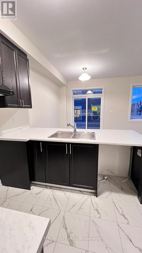 A kitchen with black cabinets and a white countertop.