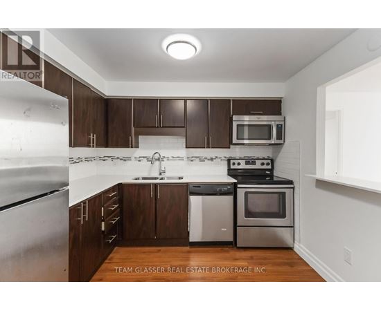 A kitchen with brown cabinets and stainless steel appliances.