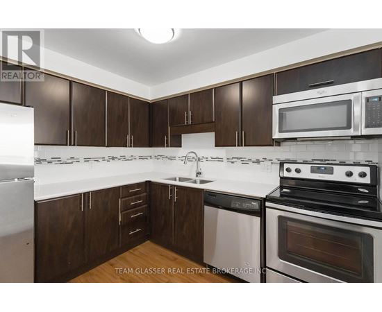 A kitchen with brown cabinets and white appliances.
