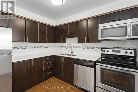 A kitchen with brown cabinets and white appliances.