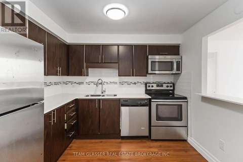 A kitchen with brown cabinets and stainless steel appliances.