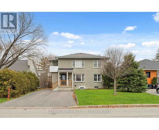A house with a grey roof and a tree in front of it.