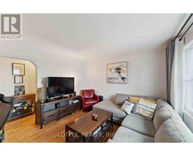 A living room with a grey couch, a red chair, a wooden coffee table, and a television.