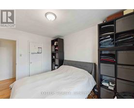 A bedroom with a bed, a nightstand, and a closet.