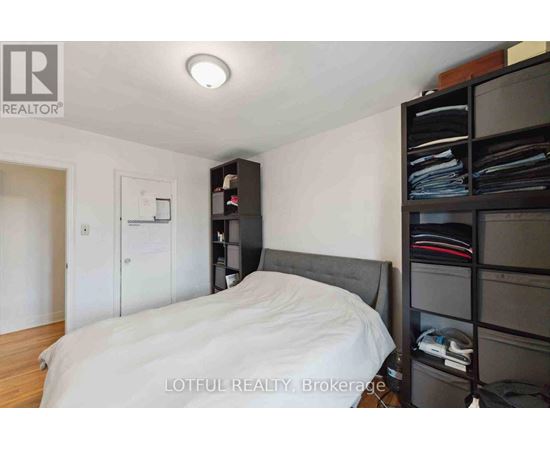 A bedroom with a bed, a nightstand, and a closet.
