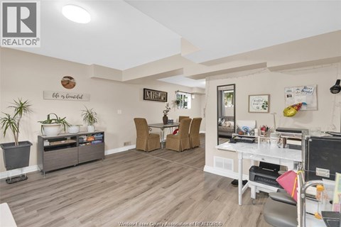 A living room with a white couch and a wooden floor.
